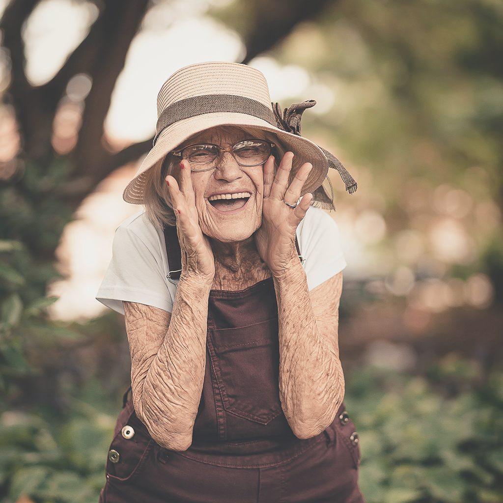 A happy elderly lady playing hide and seek, receiving professional home care. Contact Sarah today.